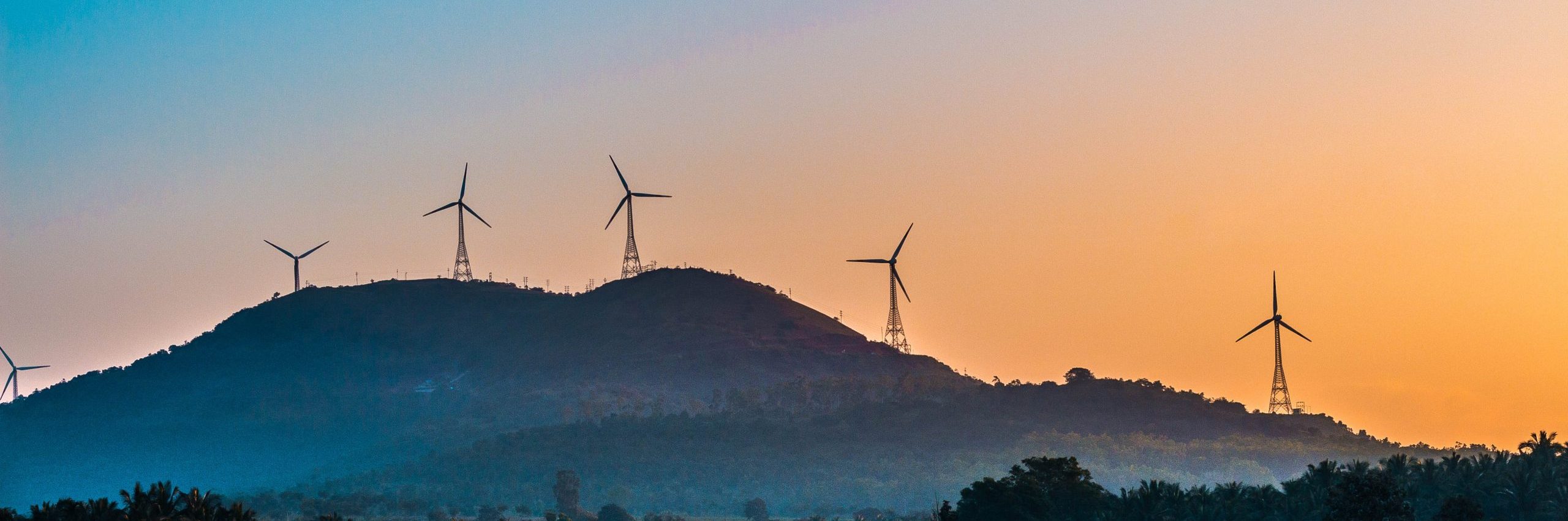 Wind turbines on a hill during sunset