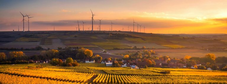 Wind turbines overlooking a field in the UK during a sunset